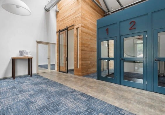 Flexwerkplekken in de Frisokazerne bij ROOTS Innovation Hub in Ede, met moderne werkunits en een warme, industriële uitstraling.