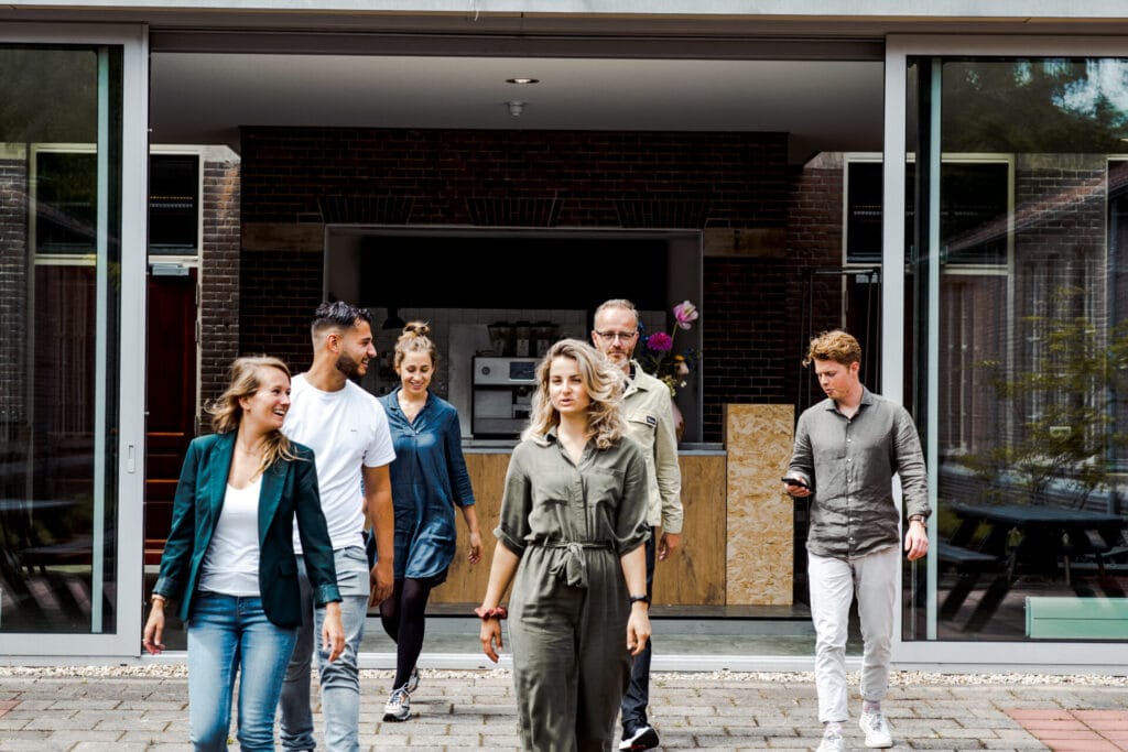 Groep jonge ondernemers loopt over het terrein van ROOTS Innovation Hub in Ede